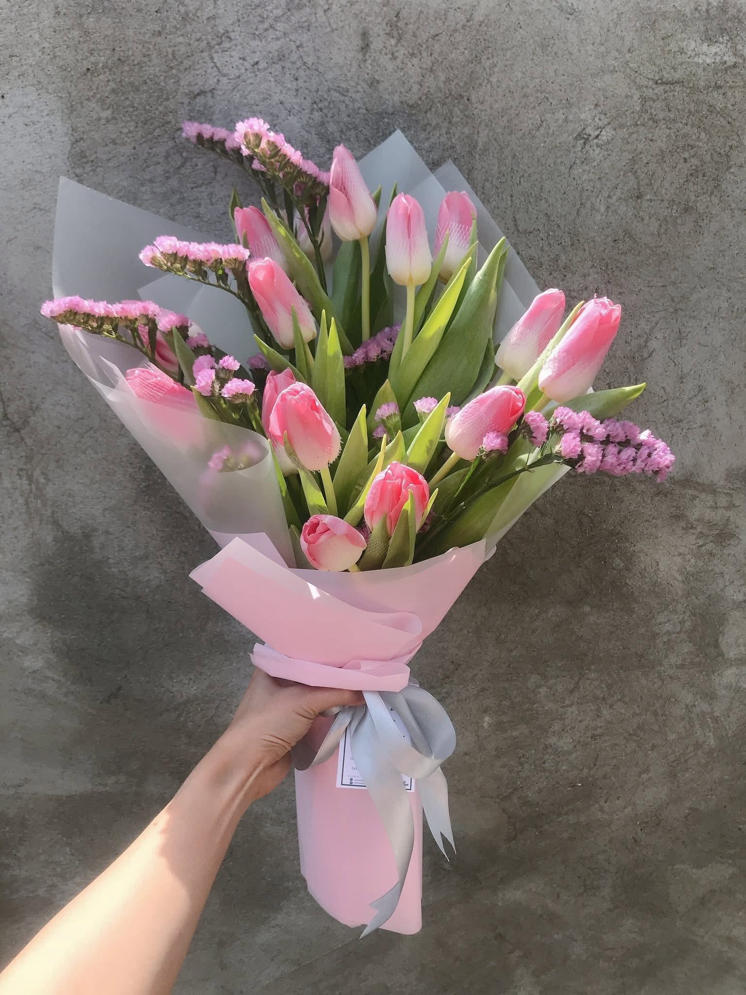 A soft white and lilac bouquet by the window