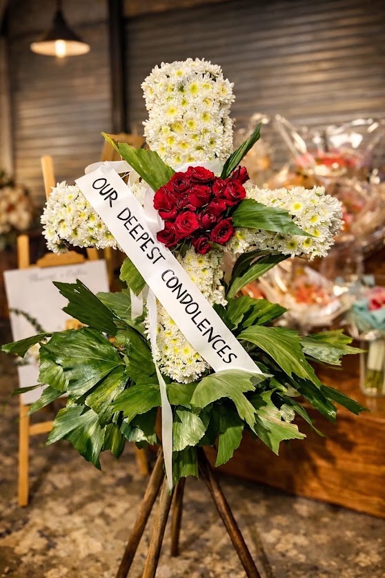 Sympathy cross arrangement of white chrysanthemums and red roses